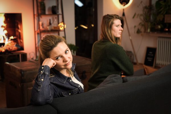 Zwei Frauen auf einem Sofa, die in unterschiedliche Richtungen schauen